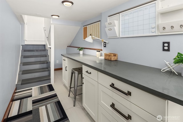 5817 28th Ave NW, Seattle, WA 98107 - kitchen featuring dark countertops, white cabinets, and light tile patterned floors