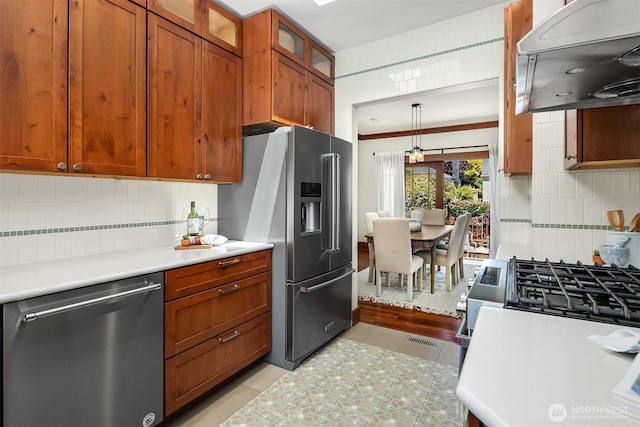 5817 28th Ave NW, Seattle, WA 98107 - kitchen with appliances with stainless steel finishes, extractor fan, light countertops, and decorative backsplash