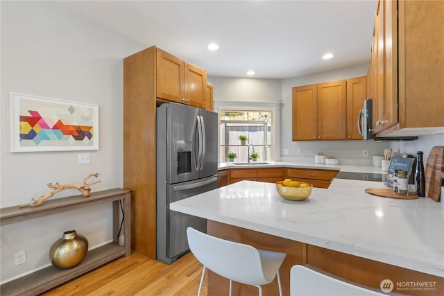 3055 49th Ave SW, Seattle, WA 98116 - kitchen with stainless steel fridge with ice dispenser, a kitchen breakfast bar, a peninsula, brown cabinets, and recessed lighting