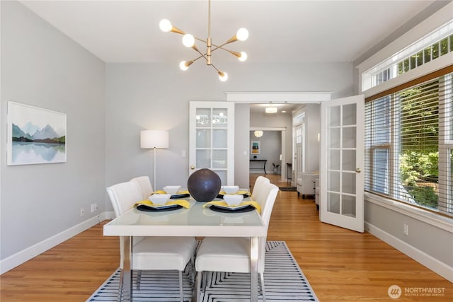 3055 49th Ave SW, Seattle, WA 98116 - dining area with french doors, light wood-type flooring, and a chandelier