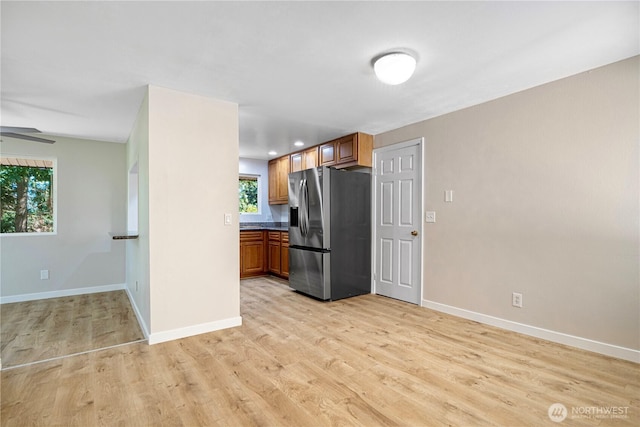 12621 SE 166th St, Renton, WA 98058 - kitchen featuring stainless steel fridge with ice dispenser, brown cabinets, light wood-type flooring, and dark countertops