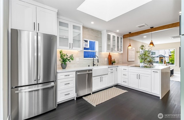 4725 37th Ave SW, Seattle, WA 98126 - kitchen with stainless steel appliances, a peninsula, dark wood-type flooring, tasteful backsplash, and light countertops