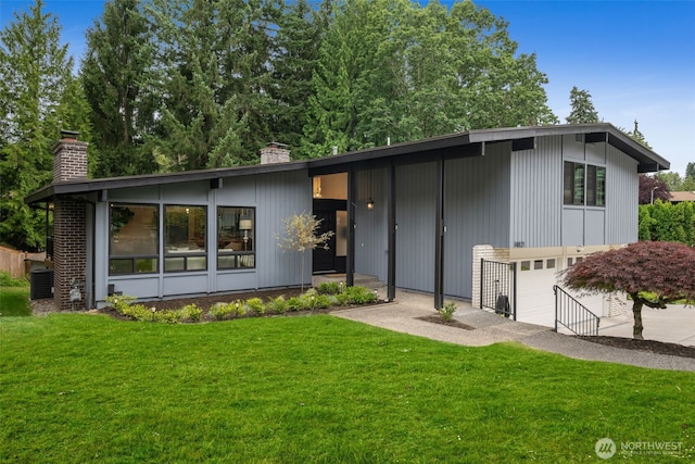 14821 117th Pl NE, Kirkland, WA 98034 - mid-century home with a chimney, an attached garage, a front lawn, and driveway