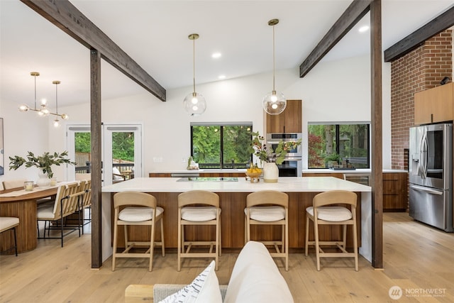 14821 117th Pl NE, Kirkland, WA 98034 - kitchen featuring appliances with stainless steel finishes, modern cabinets, light countertops, light wood-type flooring, and a kitchen breakfast bar