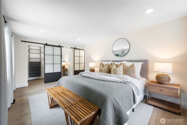 14821 117th Pl NE, Kirkland, WA 98034 - bedroom with a barn door, wood finished floors, and recessed lighting