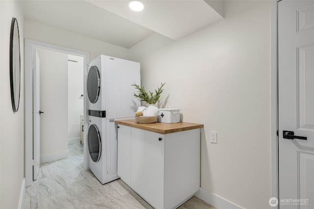 14821 117th Pl NE, Kirkland, WA 98034 - washroom featuring estacked washer and dryer, light marble finish flooring, and cabinet space