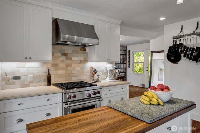 3006 43rd Ave W, Seattle, WA 98199 - kitchen featuring wall chimney range hood, high end range, backsplash, butcher block counters, and white cabinets