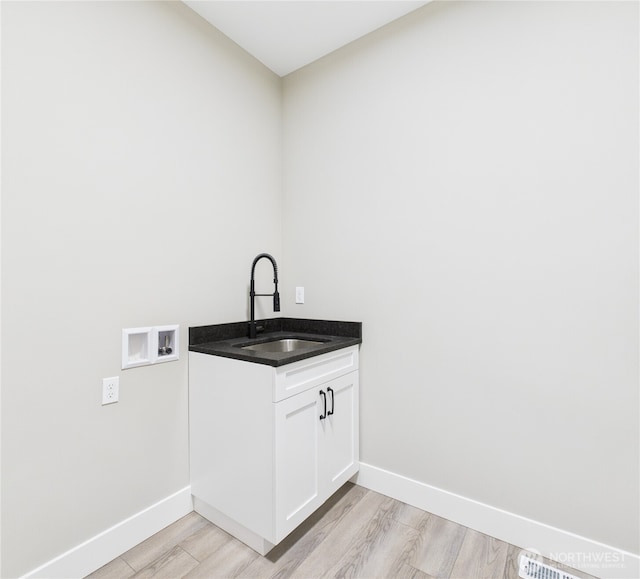 884 NE Tyler Pl E, Wenatchee, WA 98802 - washroom with washer hookup, light wood finished floors, and cabinet space