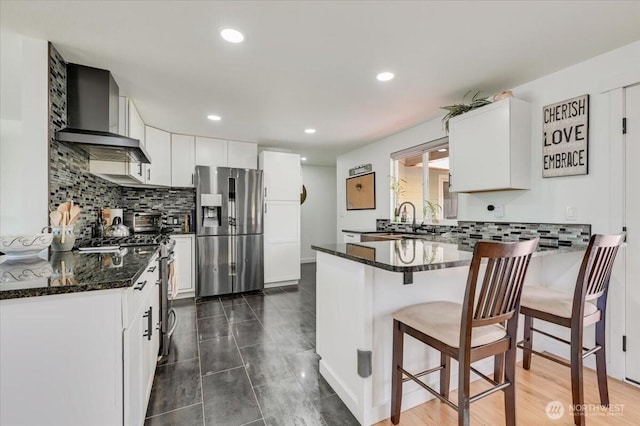 701 Mountain View Dr, Mount Vernon, WA 98273 - kitchen featuring appliances with stainless steel finishes, wall chimney range hood, a peninsula, dark stone countertops, and decorative backsplash