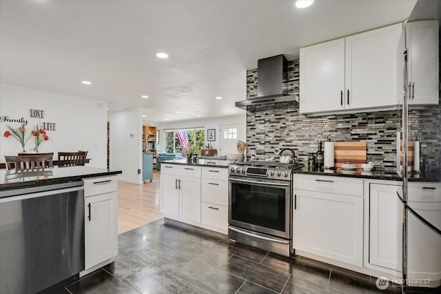 701 Mountain View Dr, Mount Vernon, WA 98273 - kitchen with appliances with stainless steel finishes, wall chimney exhaust hood, recessed lighting, backsplash, and a peninsula