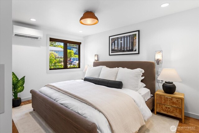 8733 21st Ave NW, Seattle, WA 98117 - bedroom with an AC wall unit, wood finished floors, and recessed lighting