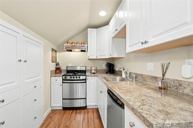 3844 Long Lake Loop SE, Olympia, WA 98503 - kitchen featuring appliances with stainless steel finishes, under cabinet range hood, lofted ceiling, light wood-type flooring, and white cabinetry