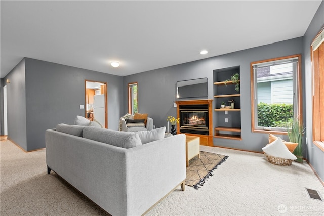 4867 N Village Ln, Bellingham, WA 98226 - carpeted living area with a glass covered fireplace, healthy amount of natural light, built in shelves, and recessed lighting