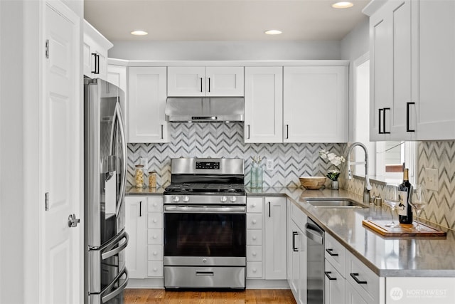 10873 SE 214th Pl, Kent, WA 98031 - kitchen with appliances with stainless steel finishes, under cabinet range hood, white cabinetry, backsplash, and recessed lighting