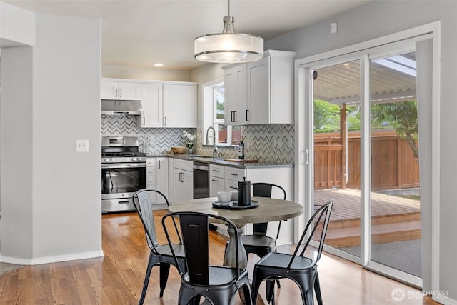 10873 SE 214th Pl, Kent, WA 98031 - kitchen with appliances with stainless steel finishes, under cabinet range hood, decorative backsplash, white cabinets, and recessed lighting
