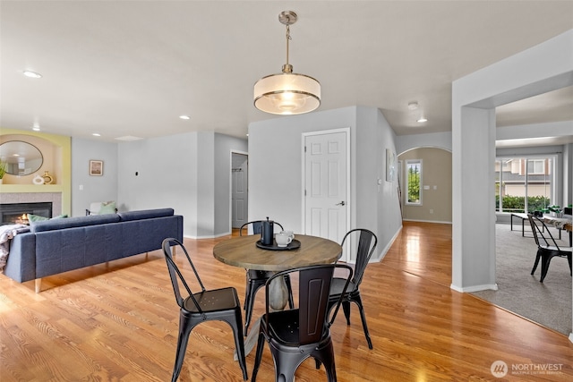 10873 SE 214th Pl, Kent, WA 98031 - dining area with arched walkways, light wood finished floors, a glass covered fireplace, and recessed lighting