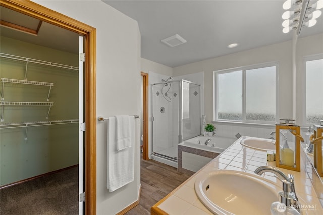 10873 SE 214th Pl, Kent, WA 98031 - full bathroom with a stall shower, double vanity, a garden tub, a spacious closet, and wood finished floors