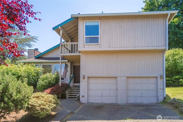 8113 S 121st St, Seattle, WA 98178 - view of front of house with a balcony, a garage, a chimney, and driveway
