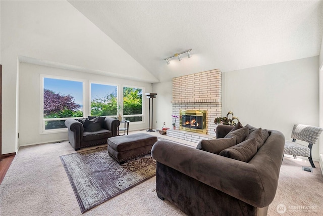8113 S 121st St, Seattle, WA 98178 - carpeted living room with track lighting, high vaulted ceiling, a brick fireplace, and a textured ceiling