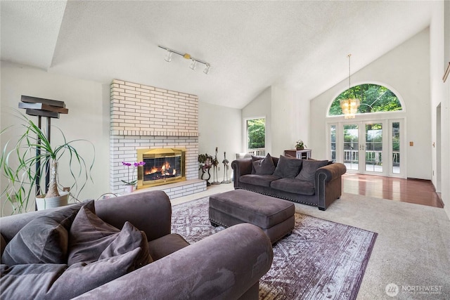 8113 S 121st St, Seattle, WA 98178 - living room with carpet, vaulted ceiling, a textured ceiling, a brick fireplace, and rail lighting
