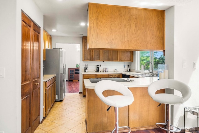 8113 S 121st St, Seattle, WA 98178 - kitchen featuring freestanding refrigerator, black electric stovetop, a peninsula, light countertops, and a kitchen breakfast bar