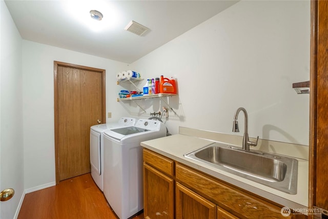 8113 S 121st St, Seattle, WA 98178 - laundry area featuring separate washer and dryer, wood finished floors, and cabinet space