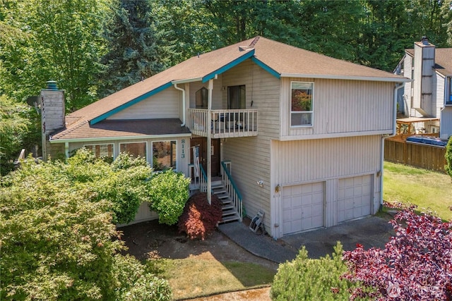8113 S 121st St, Seattle, WA 98178 - view of front facade with a balcony, an attached garage, and a chimney