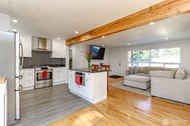 7718 50th Ave E, Tacoma, WA 98443 - kitchen featuring stainless steel electric stove, wall chimney exhaust hood, freestanding refrigerator, open floor plan, and light wood-style flooring