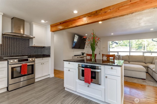 7718 50th Ave E, Tacoma, WA 98443 - kitchen featuring appliances with stainless steel finishes, range hood, open floor plan, recessed lighting, and light wood-type flooring