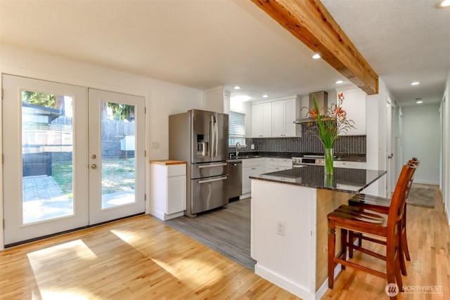 7718 50th Ave E, Tacoma, WA 98443 - kitchen featuring stainless steel appliances, french doors, wall chimney range hood, light wood-style flooring, and beam ceiling