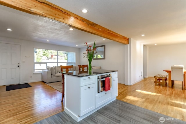 7718 50th Ave E, Tacoma, WA 98443 - kitchen featuring stainless steel oven, light wood-style floors, dark countertops, recessed lighting, and white cabinetry