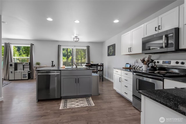 19826 207th Street Ct E, Orting, WA 98360 - kitchen with appliances with stainless steel finishes, white cabinetry, recessed lighting, dark wood-style flooring, and dark stone countertops