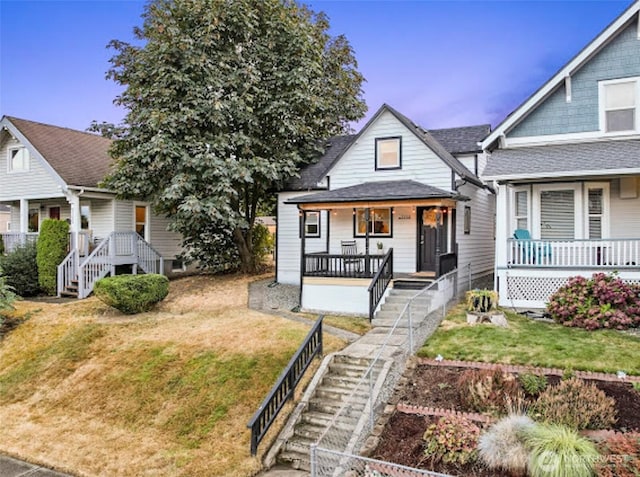 2118 S Sheridan Ave, Tacoma, WA 98405 - view of front facade with covered porch, a front yard, roof with shingles, and stairs