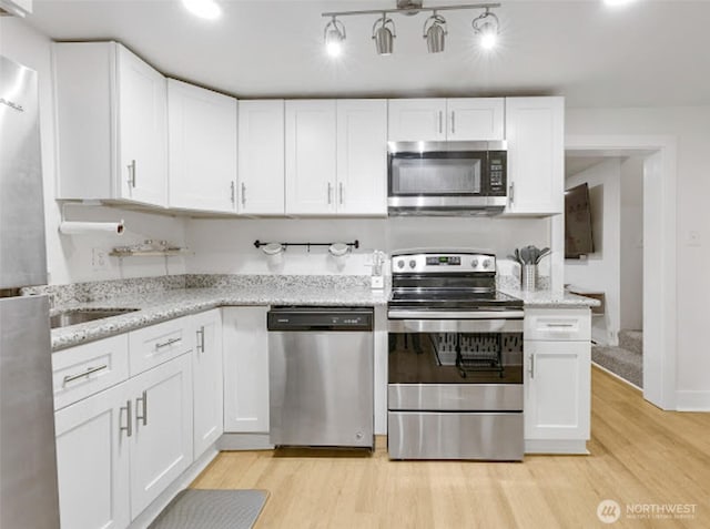 2118 S Sheridan Ave, Tacoma, WA 98405 - kitchen featuring stainless steel appliances, light wood finished floors, and white cabinets