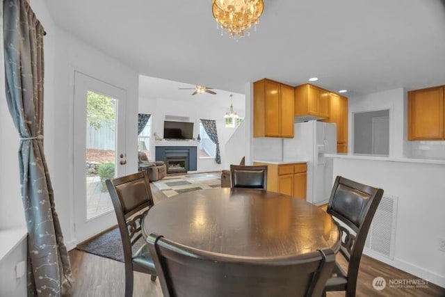 19168 110th Pl SE Unit 19168, Renton, WA 98055 - dining space featuring a fireplace, a chandelier, wood finished floors, ceiling fan, and recessed lighting