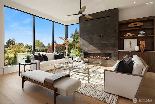 1032 89th Ave NE, Bellevue, WA 98004 - living area featuring a high end fireplace, ceiling fan, wood finished floors, plenty of natural light, and recessed lighting