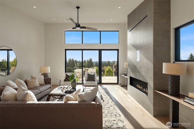 1032 89th Ave NE, Bellevue, WA 98004 - living room with ceiling fan, a tiled fireplace, healthy amount of natural light, a high ceiling, and recessed lighting