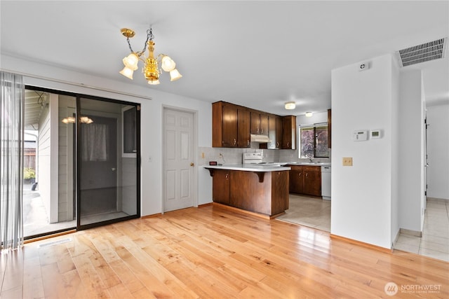 802 39th Pl, Bellingham, WA 98229 - kitchen featuring a chandelier, light countertops, white appliances, light wood-style flooring, and a peninsula