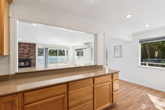 7519 Atchinson Dr SE, Olympia, WA 98513 - kitchen with an AC wall unit, healthy amount of natural light, light wood finished floors, ornamental molding, and a brick fireplace
