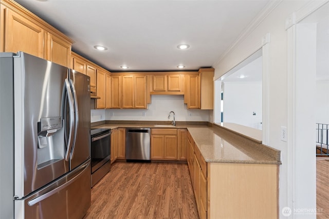 7519 Atchinson Dr SE, Olympia, WA 98513 - kitchen with stainless steel appliances, wood finished floors, light stone counters, ornamental molding, and recessed lighting