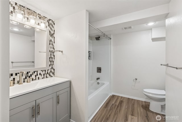 7519 Atchinson Dr SE, Olympia, WA 98513 - bathroom with wood finished floors, vanity, backsplash, and shower / washtub combination