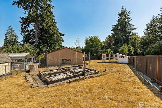 7519 Atchinson Dr SE, Olympia, WA 98513 - fenced backyard featuring a garden and an outbuilding