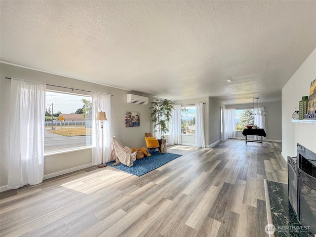 101 E Whidby Ave, Port Angeles, WA 98362 - living area featuring an AC wall unit, a textured ceiling, wood finished floors, a chandelier, and a premium fireplace