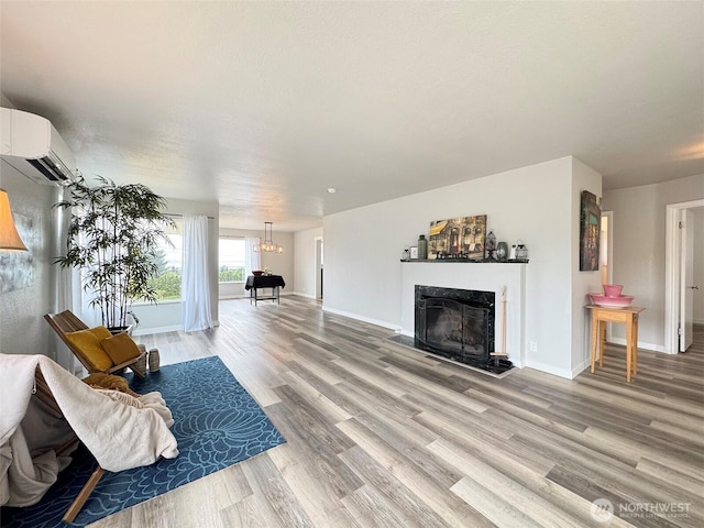 101 E Whidby Ave, Port Angeles, WA 98362 - living room featuring an AC wall unit, light wood-style floors, a fireplace, and a chandelier