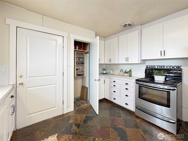 101 E Whidby Ave, Port Angeles, WA 98362 - kitchen featuring stainless steel electric range oven, stone tile floors, white cabinetry, and light countertops