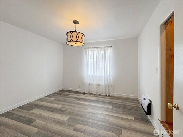 101 E Whidby Ave, Port Angeles, WA 98362 - empty room with wood finished floors and heating unit