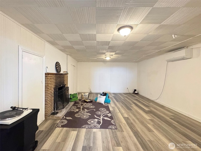 101 E Whidby Ave, Port Angeles, WA 98362 - living area with a wall mounted AC, a brick fireplace, and wood finished floors