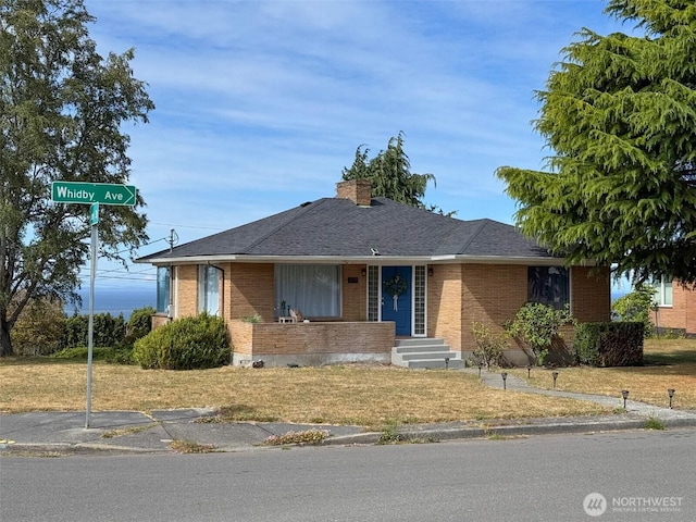 101 E Whidby Ave, Port Angeles, WA 98362 - view of front facade with brick siding, a chimney, a front lawn, and roof with shingles