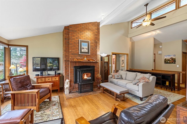 190 Bluffs Dr Unit 1, Port Townsend, WA 98368 - living room featuring a wood stove, a ceiling fan, light wood-style flooring, high vaulted ceiling, and beam ceiling