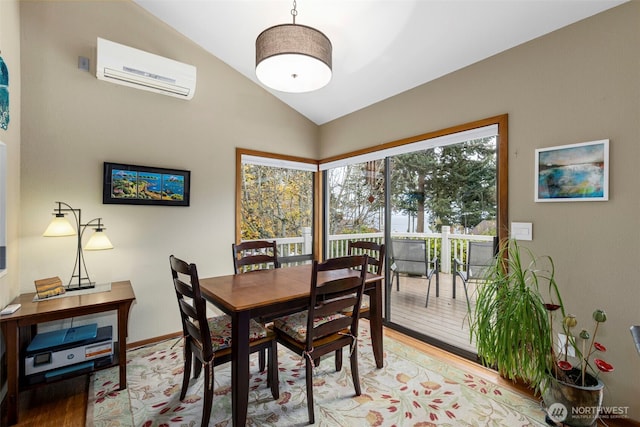 190 Bluffs Dr Unit 1, Port Townsend, WA 98368 - dining room with a wall unit AC, vaulted ceiling, and light wood-style floors